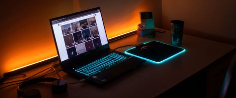 A laptop open on a desk in a dim room