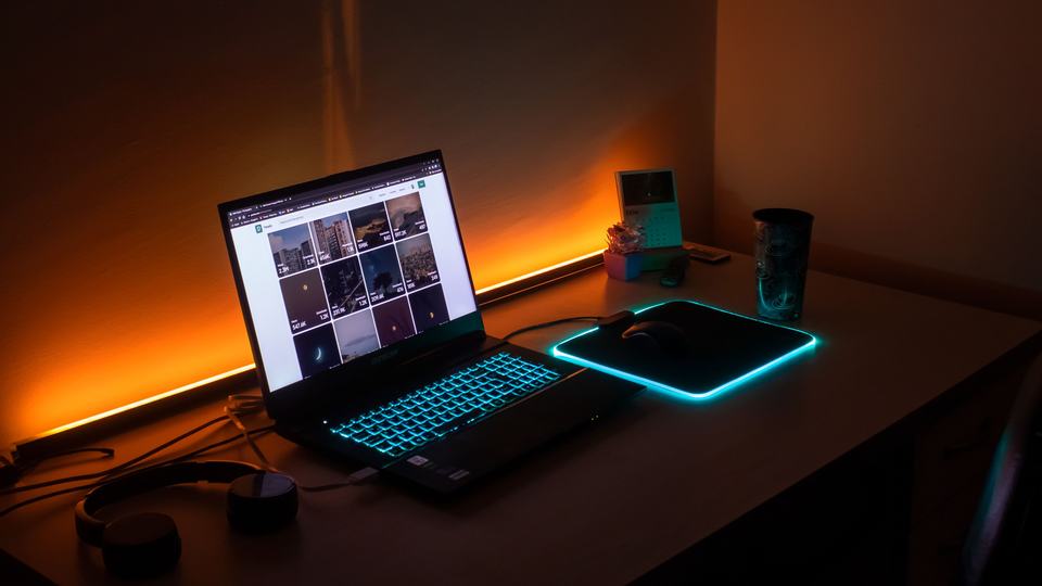 A laptop open on a desk in a dim room