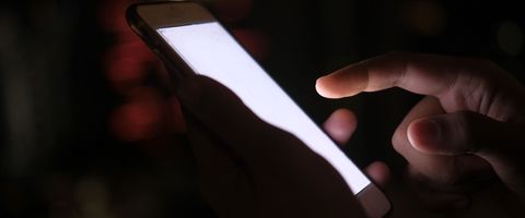 A phone lit up in a hand at night