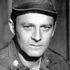 Larry Linville as President Grimshaw