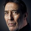 Ciarán Hinds as Reverend Dennis Hasset