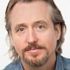 Linus Roache as Father Greg Pilkington