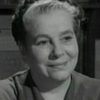Nora Gordon as Woman in Hall